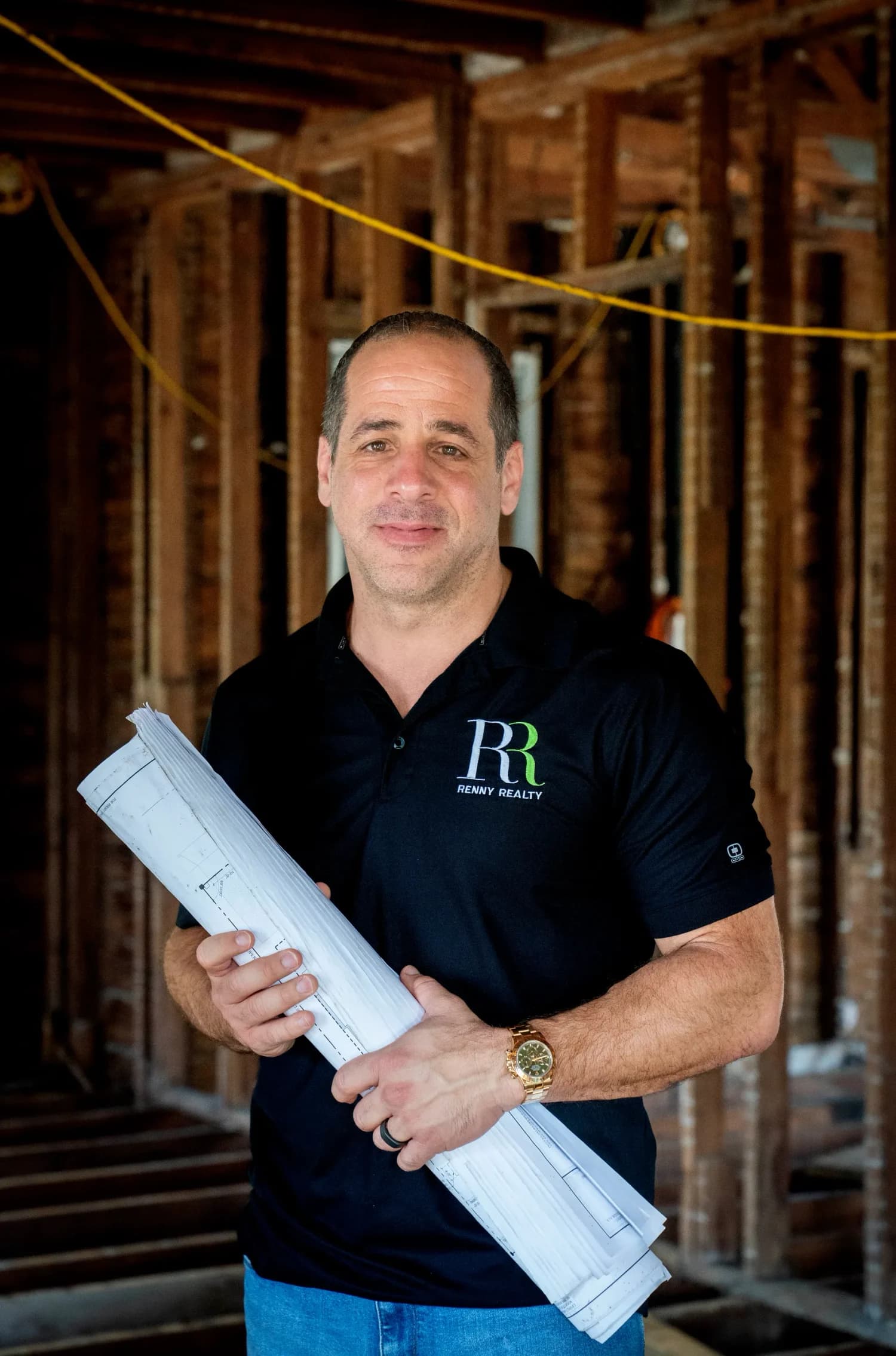 Gus Renny inside a gutted historic home, plans in hand